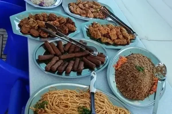 Assortiment gebakken en gegrilde gerechten, waaronder loempia's, kip en rijst, op de lunchtafel aan boord