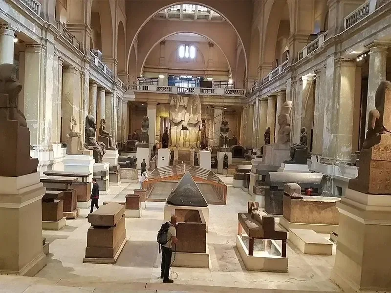 Grande salle du Musée égyptien du Caire, bordée de statues antiques, de sarcophages et d'objets de pierre exposés
