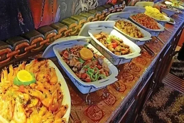 Buffet de fruits de mer et de plats égyptiens : crevettes, poulet assaisonné et riz