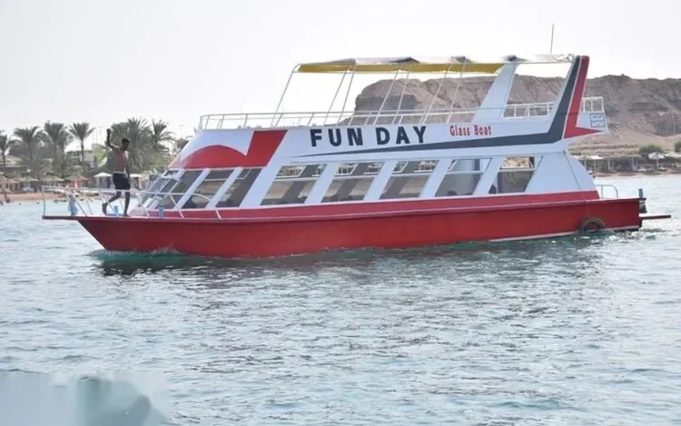 Лодка со стеклянным дном Fun Day идёт у берега, мальчик на носу машет в камеру