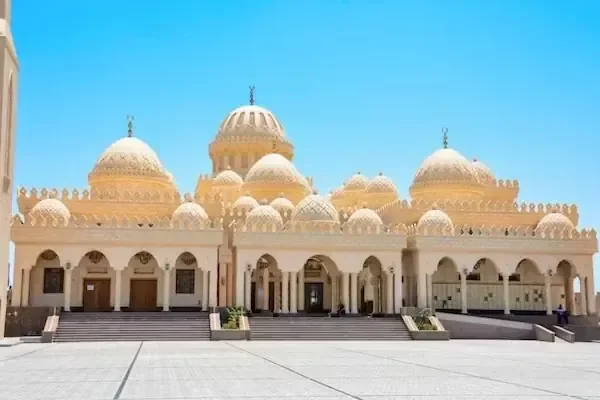 مسجد الميناء بمجموعة قبابه ومآذنه البيضاء والذهبية تحت سماء زرقاء صافية