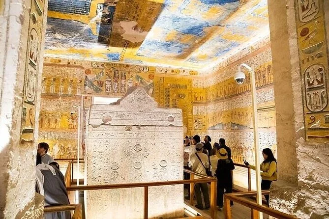 Felgekleurde hiërogliefenreliëfs in blauw, geel en wit bedekken de muren en het plafond van een koninklijke grafkamer