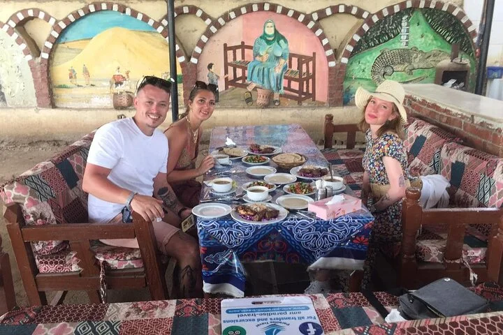 Gasten aan een versierde buitentafel genieten samen van de lunch tijdens de middagpauze van de tour