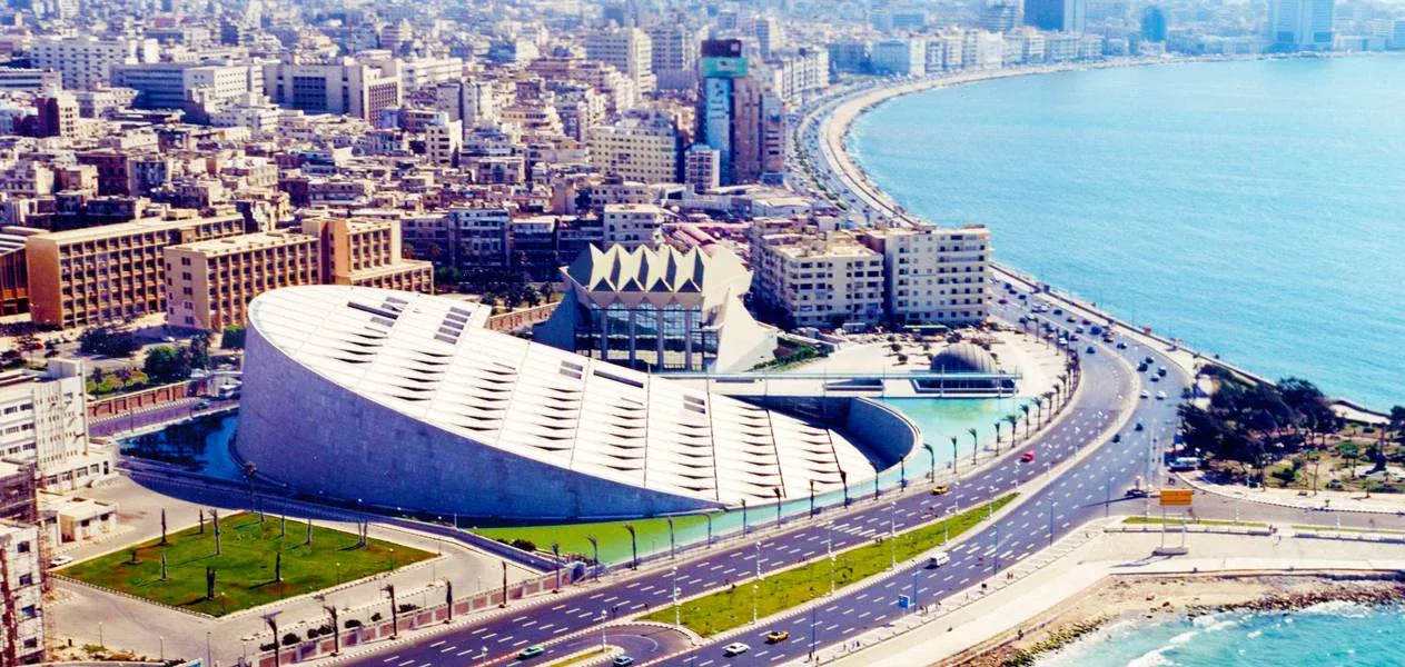 Luftaufnahme der Corniche von Alexandria mit der fächerförmigen Bibliotheca Alexandrina an der Mittelmeerküste