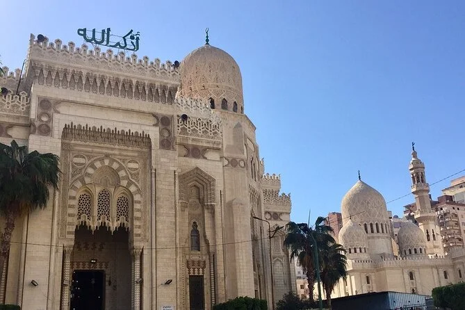 Untersicht auf Steinfassade, Kuppel und Minarett der Abu-al-Abbas-al-Mursi-Moschee vor klarem blauem Himmel