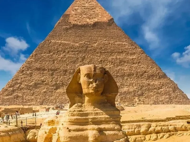 Nahaufnahme der Großen Sphinx von Gizeh von vorn, direkt dahinter die Chephren-Pyramide