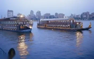 رواد مطعم يجلسون على طاولات مضاءة بالشموع داخل مطعم أو سفينة سياحية في المساء