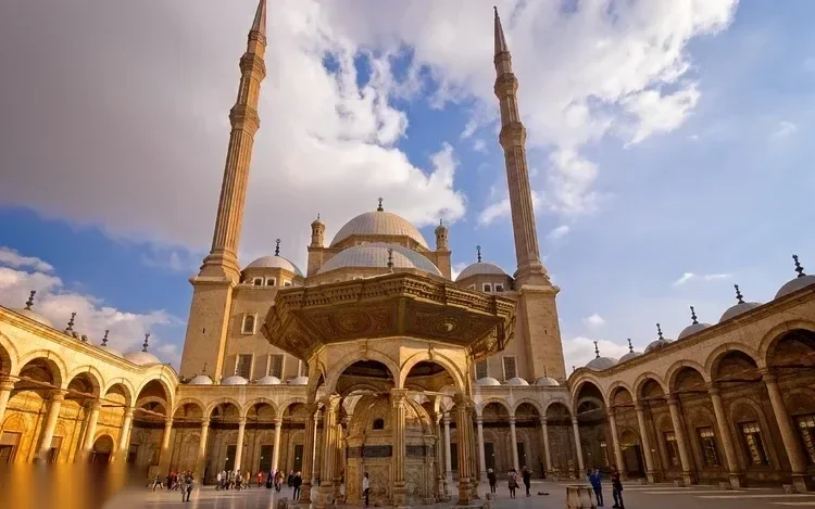 راقص تنورة يدور بتنورة كبيرة ملونة متعددة الطبقات على مسرح السفينة بينما تشاهد فرقة موسيقية والجمهور