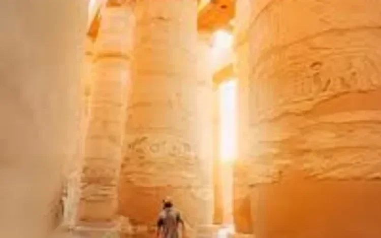 Sunlight streams between towering stone columns inside a temple hall