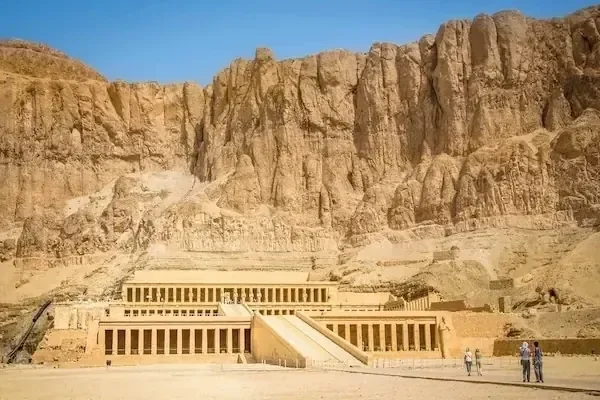 De terrasvormige zuilengangen van de Hatsjepsoet-tempel aan de voet van steile woestijnrotsen