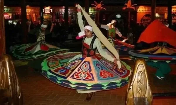夜晚，一位旋转舞者身穿彩色旋转裙表演塔努拉舞