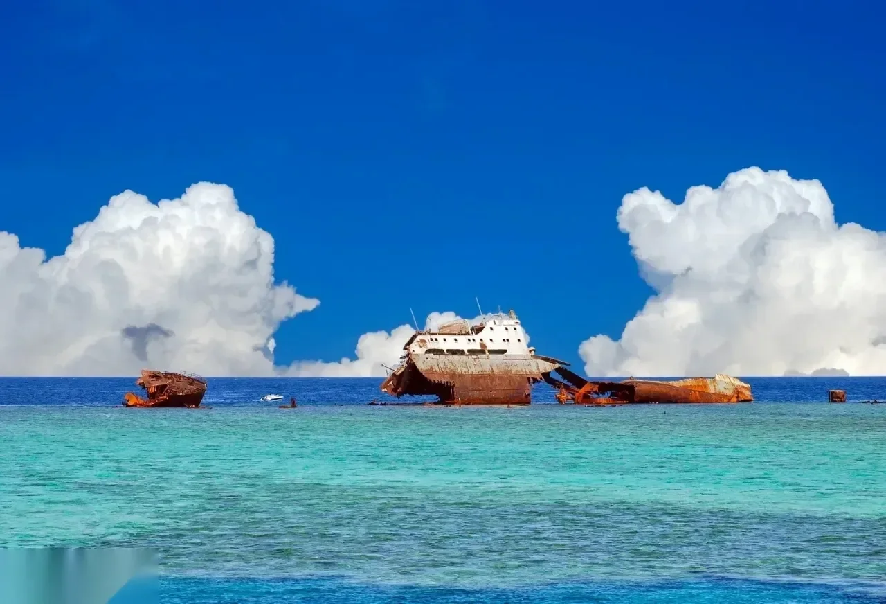 Grande épave de cargo rouillée brisée sur un récif sous un ciel dramatique de cumulus imposants
