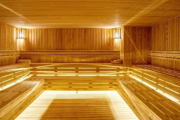 Empty traditional wooden sauna room with tiered wooden benches and warm amber lighting